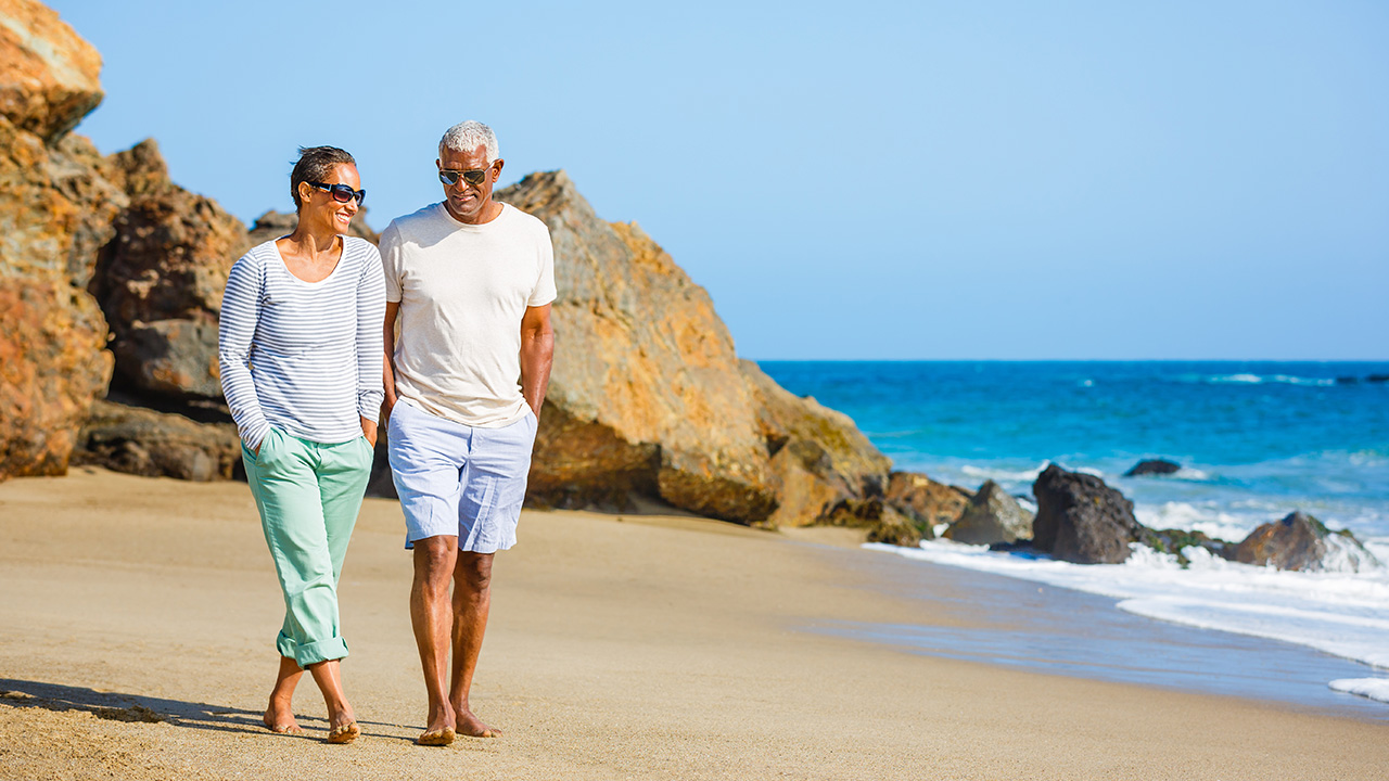senior couple walking on a beach
