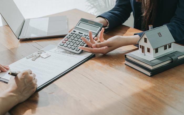 two people discussing housing costs with calculator notes