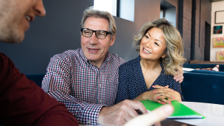 man and wife sitting down with a financial planner