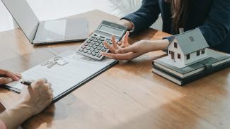 two people discussing housing costs with calculator notes