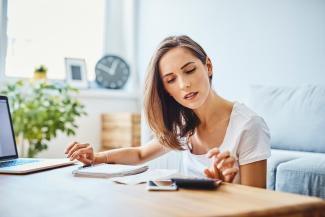 young women using a calculator in her living room