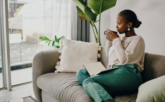 women with mug looking out glass doors