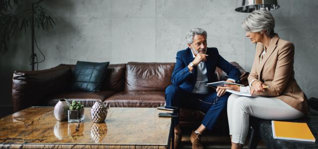businessman and businesswoman on leather chairs